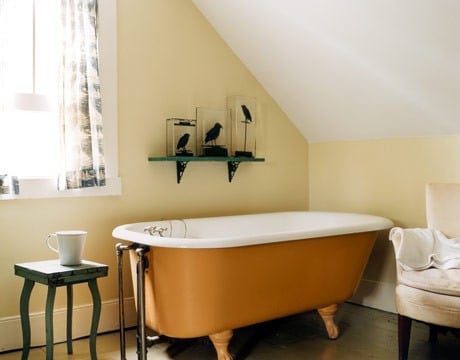 salle de bains aux couleurs claires avec une baignoire orange
