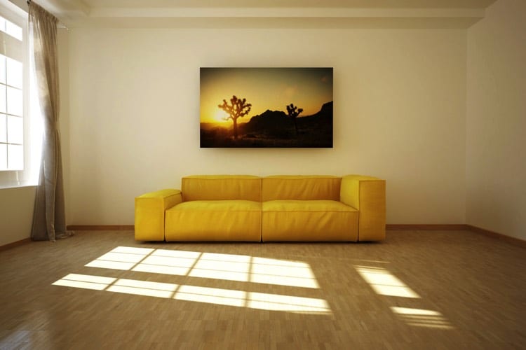 Large sofa jaune dans un salon spacieux et légèrement éclairé pour une atmosphère confortable, calme, chaleureuse et intimiste