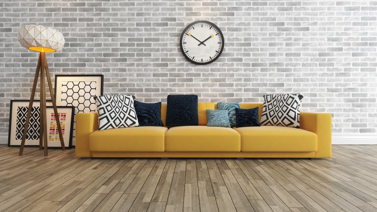 Canapé jaune crème avec des coussins aux imprimés géométriques, son plancher en bois doux, son papier style de briques et sa lampe ultra design